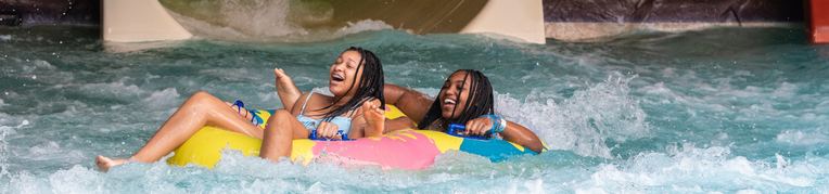 Two guest in a floatie going down a slide at the Indoor WaterPark