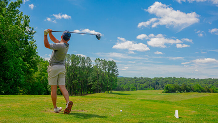 A guest teeing off at Woodstone Meadows Golf Course at Massanutten Resort